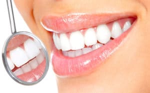 extreme close up of woman smiling with tiny dental mirror