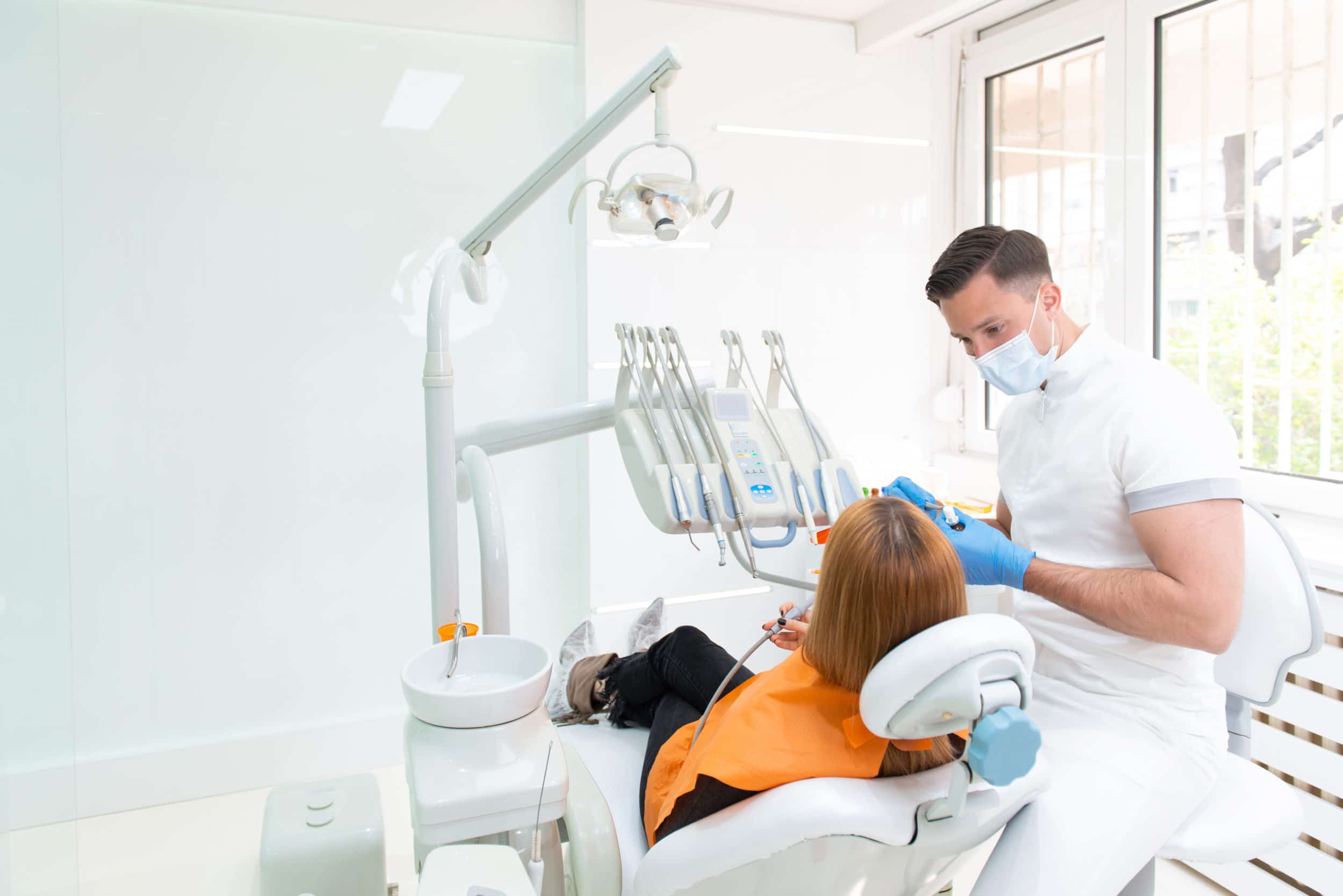 Male dentist with female patient in dental clinic.