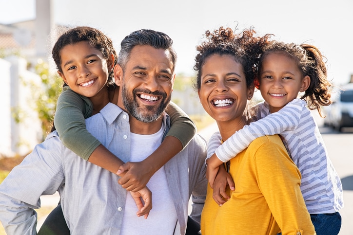 family with wide husband and two kids posing for picture