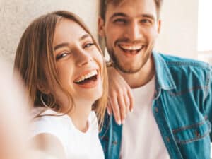 Smiling beautiful girl and her handsome boyfriend taking selfie