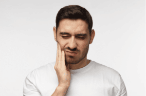 young man feeling pain holding his cheek with hand