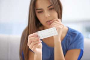 Young woman with pills at home 300x200 1