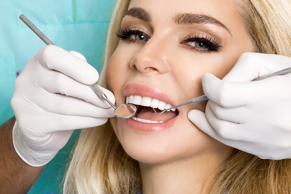Woman smiling with picture-perfect teeth after getting porcelain veneers placed.