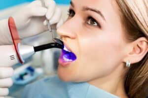 Woman at dentist getting cosmetic dental bonding treatment.