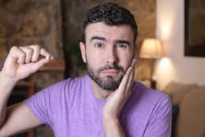 Man looking sad while holding his tooth that fell out