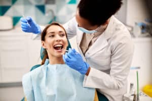 Woman happily receiving her end-of-year dental exam to keep her teeth healthy and clean in the new year.