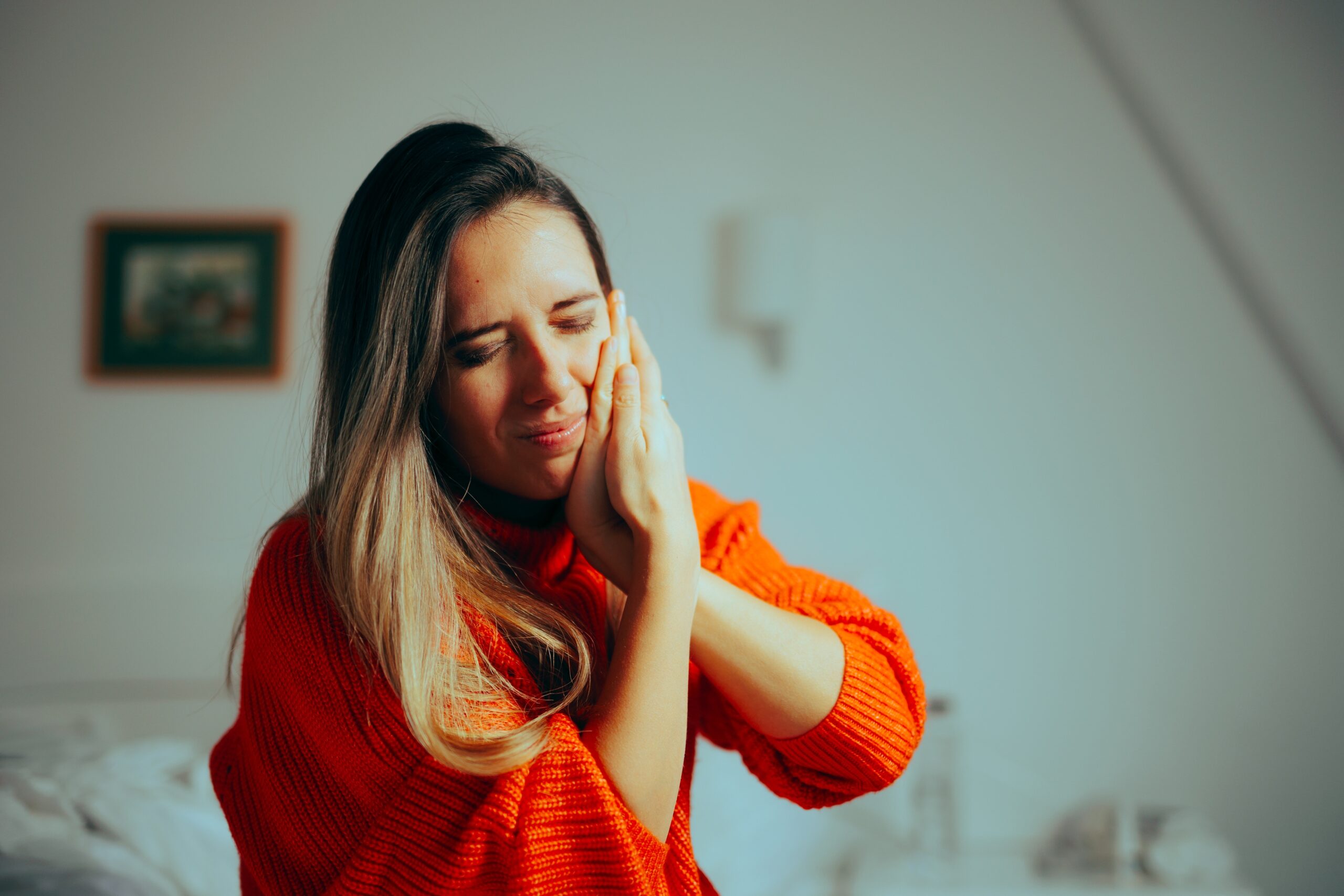 Woman holding her jaw in pain caused by bruxism