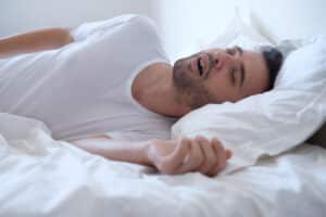 Man snoring while sleeping due to sleep apnea