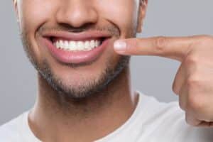 Smiling man pointing to his tooth enamel